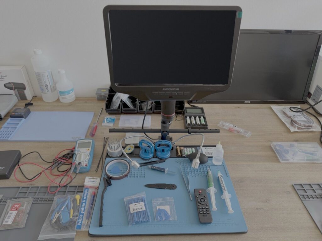 IT-Forensik-Labor 6 Digitales Mikroskop über einer ESD-Arbeitsmatte mit Pinzetten, Multimeter und Präzisionswerkzeug